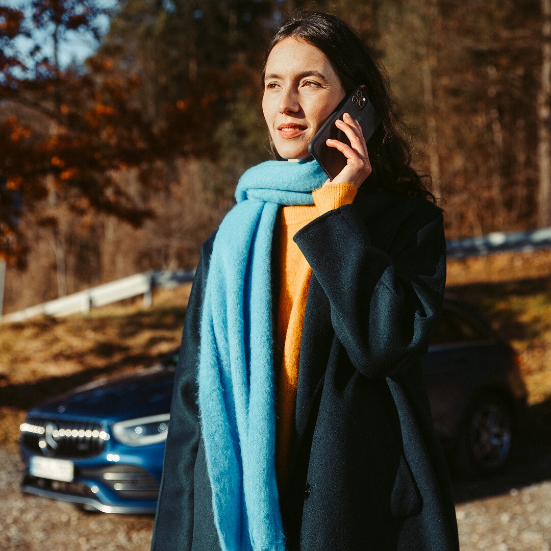 หากไม่สามารถเดินทางต่อไปได้ | ภาพรวมการให้บริการความช่วยเหลือเมื่อรถเสีย | เมอร์เซเดส-เบนซ์ ผู้หญิงคนหนึ่งยืนอยู่หน้า Mercedes SUV ของเธอและโทรด้วยสมาร์ทโฟน